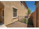 Exterior view of gravel backyard with fenced in grass area and tan home with window at 31046 N 138Th Ave, Peoria, AZ 85383