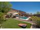 Inviting backyard with lush artificial turf, swimming pool, and comfortable lounge area at 31046 N 138Th Ave, Peoria, AZ 85383