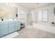 Bright bathroom with double vanity, soaking tub, glass shower, and neutral tile flooring at 31046 N 138Th Ave, Peoria, AZ 85383