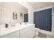 Well-lit bathroom with double sinks, white cabinetry, and a charming nautical-themed shower curtain at 31046 N 138Th Ave, Peoria, AZ 85383