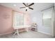 Charming bedroom with a modern ceiling fan, bright pink walls, and plenty of sunshine at 31046 N 138Th Ave, Peoria, AZ 85383