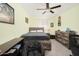 Well-lit bedroom is complete with comfortable, rustic furniture, ceiling fan, and bright walls at 31046 N 138Th Ave, Peoria, AZ 85383