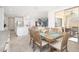 View of the dining room with a wooden table, six chairs, and a bright, open kitchen with an island at 31046 N 138Th Ave, Peoria, AZ 85383