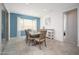 Dining room with a wooden table, six chairs, tile floors, a large window and a light blue accent wall at 31046 N 138Th Ave, Peoria, AZ 85383