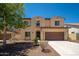 Charming two-story home featuring a brown two car garage, desert landscaping, and a welcoming entry at 31046 N 138Th Ave, Peoria, AZ 85383