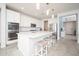 Bright kitchen featuring white cabinets, tile floors, stainless steel appliances and a large kitchen island with bar stool seating at 31046 N 138Th Ave, Peoria, AZ 85383