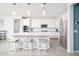 Bright kitchen with stainless steel appliances, white cabinets, large island with bar seating and modern pendant lighting at 31046 N 138Th Ave, Peoria, AZ 85383