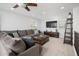 Cozy loft area with a ceiling fan, large sofa, wooden coffee table and a wall-mounted TV at 31046 N 138Th Ave, Peoria, AZ 85383