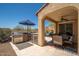 A full outdoor kitchen with stainless appliances and dining area is connected to the covered patio at 31046 N 138Th Ave, Peoria, AZ 85383