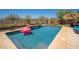 Beautiful backyard pool with a flamingo float, desert landscaping, and relaxing lounge area at 31046 N 138Th Ave, Peoria, AZ 85383
