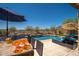 Outdoor bar with seating and entertaining area, overlooking a pristine pool and lush landscaping at 31046 N 138Th Ave, Peoria, AZ 85383