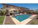 Beautiful backyard pool with lounge seating, an outdoor umbrella and a view of the home's exterior at 31046 N 138Th Ave, Peoria, AZ 85383