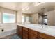 Well-lit bathroom featuring a soaking tub, large mirror, and double sink vanity at 42160 W Arvada Ct, Maricopa, AZ 85138
