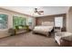 Bright Primary bedroom with large windows, neutral walls, and stylish seating arrangement at 42160 W Arvada Ct, Maricopa, AZ 85138