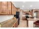The kitchen features wood cabinets, granite countertops, and stainless steel appliances at 42160 W Arvada Ct, Maricopa, AZ 85138