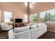 Well lit living room featuring a comfy sofa, entertainment center, and leafy green views at 42160 W Arvada Ct, Maricopa, AZ 85138