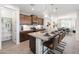 A stylish kitchen featuring brown cabinets, stainless steel appliances, a spacious island with seating, and a walk-in pantry at 4961 W Walatowa St, Laveen, AZ 85339