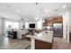 Open-concept kitchen and living area with island seating and stainless steel appliances at 4961 W Walatowa St, Laveen, AZ 85339