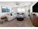 Cozy living room features neutral tones, a plush sectional sofa, stylish decor, and a ceiling fan at 4961 W Walatowa St, Laveen, AZ 85339