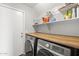Modern laundry room with a butcher block counter, Samsung washer/dryer, and ample shelving for storage at 5133 E Juana Ct, Cave Creek, AZ 85331
