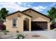 Inviting single-story home featuring desert landscaping and a dark brown, two car garage at 5827 W Coplen Farms Rd, Laveen, AZ 85339