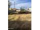 Overgrown backyard has a partially dismantled deck or structure, tall grass at 8022 E 1St Ave, Mesa, AZ 85208