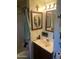 The vanity area features a traditional framed mirror, light fixture and dark wood cabinet at 8022 E 1St Ave, Mesa, AZ 85208