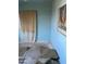 Bedroom with blue painted walls and unfinished flooring and an old curtain at 8022 E 1St Ave, Mesa, AZ 85208
