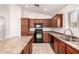 Open kitchen boasts tile flooring, updated cabinets, and stainless steel sink at 8104 S 73Rd Dr, Laveen, AZ 85339