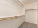 Bright walk-in closet with wooden clothes rails and gray carpeting at 8104 S 73Rd Dr, Laveen, AZ 85339