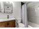 Modern bathroom showcasing black fixtures, wood vanity, and black and white marble-style tile at 8143 E Whitton Ave, Scottsdale, AZ 85251