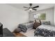 Cozy bedroom with twin beds, ceiling fan, wood floors, and a window with natural light at 8143 E Whitton Ave, Scottsdale, AZ 85251