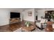 Open-concept living room showcasing a modern TV stand, hardwood floors and a dining area at 8143 E Whitton Ave, Scottsdale, AZ 85251