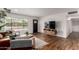 Bright living room with hardwood floors, modern decor, and a large window overlooking the front yard at 8143 E Whitton Ave, Scottsdale, AZ 85251