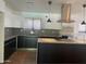 Modern kitchen with sleek white cabinetry, gray countertops, stainless steel appliances, and black accents at 8520 E Mackenzie Dr, Scottsdale, AZ 85251