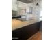 Modern kitchen island with light countertop and dark wood base, with stainless steel appliances in the background at 8520 E Mackenzie Dr, Scottsdale, AZ 85251