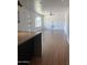 Partially obstructed view of a living room with light wood floors, white walls, and accent ceiling fan at 8520 E Mackenzie Dr, Scottsdale, AZ 85251