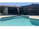 A stunning pool featuring steps, a covered patio, and a lush green backyard at 8520 E Mackenzie Dr, Scottsdale, AZ 85251