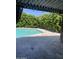 Tranquil pool area with lush greenery, stone patio, and covered seating space at 8520 E Mackenzie Dr, Scottsdale, AZ 85251