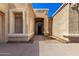 Home's arched, wooden front door with sidelight window on a sunny day at 870 E Megan St, Gilbert, AZ 85295
