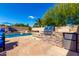 Backyard pool featuring a stone grill and serving area with a mini fridge at 870 E Megan St, Gilbert, AZ 85295