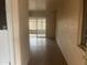 Hallway featuring neutral brick walls, tile floors, and a view into the enclosed sunroom at 10012 W Lakeview Cir, Sun City, AZ 85351