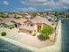 An aerial of a tan house in a quiet neighborhood, highlighting its well-kept lawn and landscaping at 10308 E Osage Ave, Mesa, AZ 85212