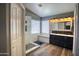 Bright bathroom featuring a glass-enclosed shower, a bench seat, and dark vanity with a double sink at 10308 E Osage Ave, Mesa, AZ 85212