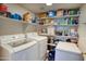 A well-organized laundry room with washer, dryer, shelving, and ample storage space at 10308 E Osage Ave, Mesa, AZ 85212