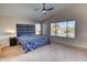 Spacious main bedroom with a plush blue bedspread, vaulted ceiling, and plenty of natural light at 10308 E Osage Ave, Mesa, AZ 85212