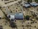 A drone shot of a ranch style house featuring an encircling driveway and multiple outbuildings at 10622 N Malachite Way, Casa Grande, AZ 85122