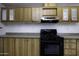 Kitchen with wood cabinets, black appliances and laminate countertops at 10622 N Malachite Way, Casa Grande, AZ 85122