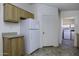 A kitchen showcases cabinets and a refrigerator alongside a doorway to the laundry area at 10622 N Malachite Way, Casa Grande, AZ 85122