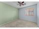 Bedroom with neutral carpet, ceiling fan, and a window providing natural light at 11405 W Windsor Ave, Avondale, AZ 85392